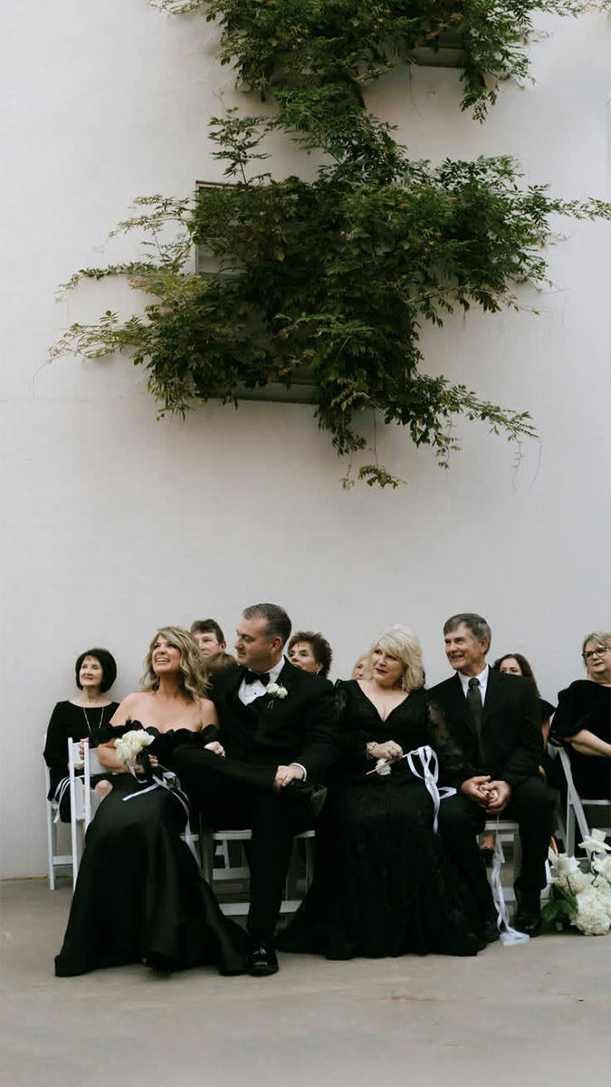 Guests in elegant black-tie attire seated at a wedding ceremony